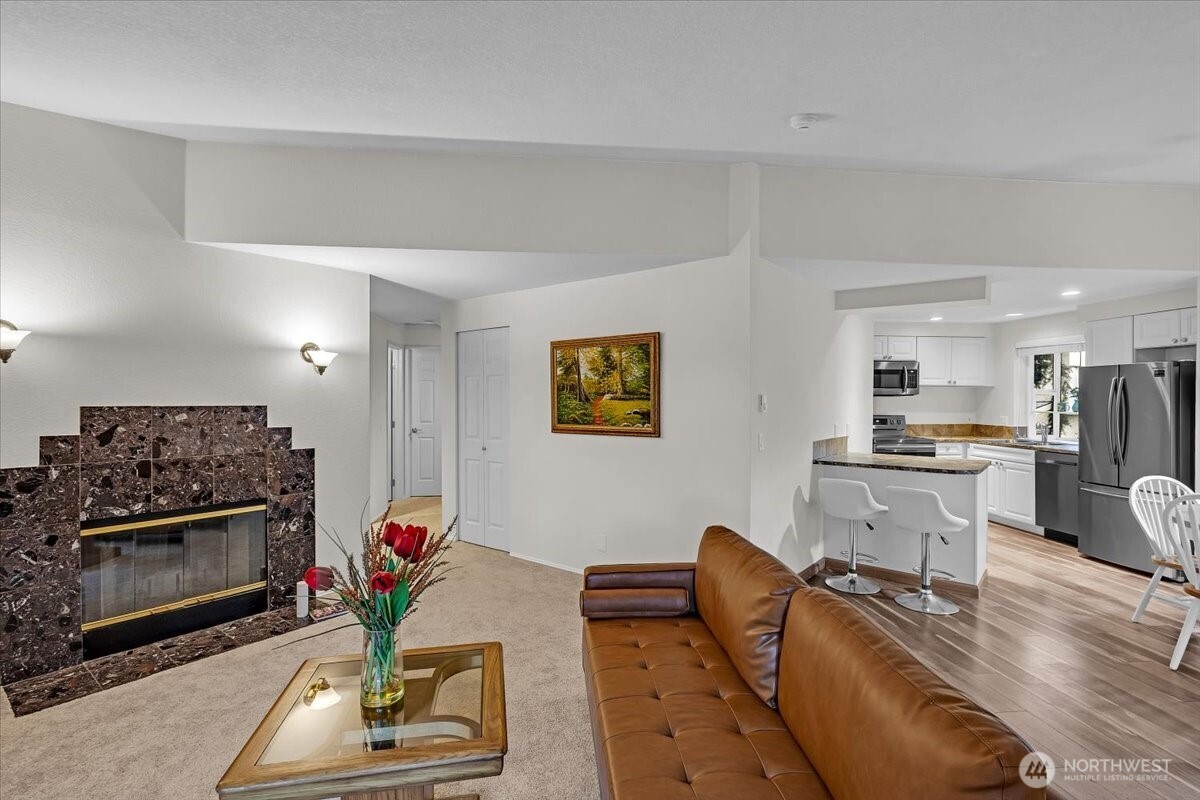 8653 Avondale Road Northeast, Unit D208 Redmond, WA 98052 - Photo 5 of 32 a living room with furniture a flat screen tv and kitchen view