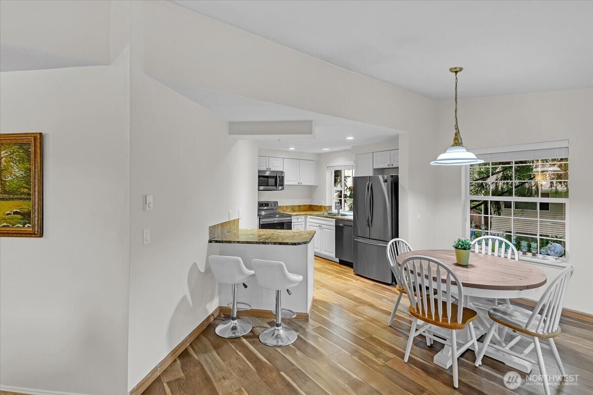 8653 Avondale Road Northeast, Unit D208 Redmond, WA 98052 - Photo 10 of 32 a dining room with furniture a chandelier and wooden floor