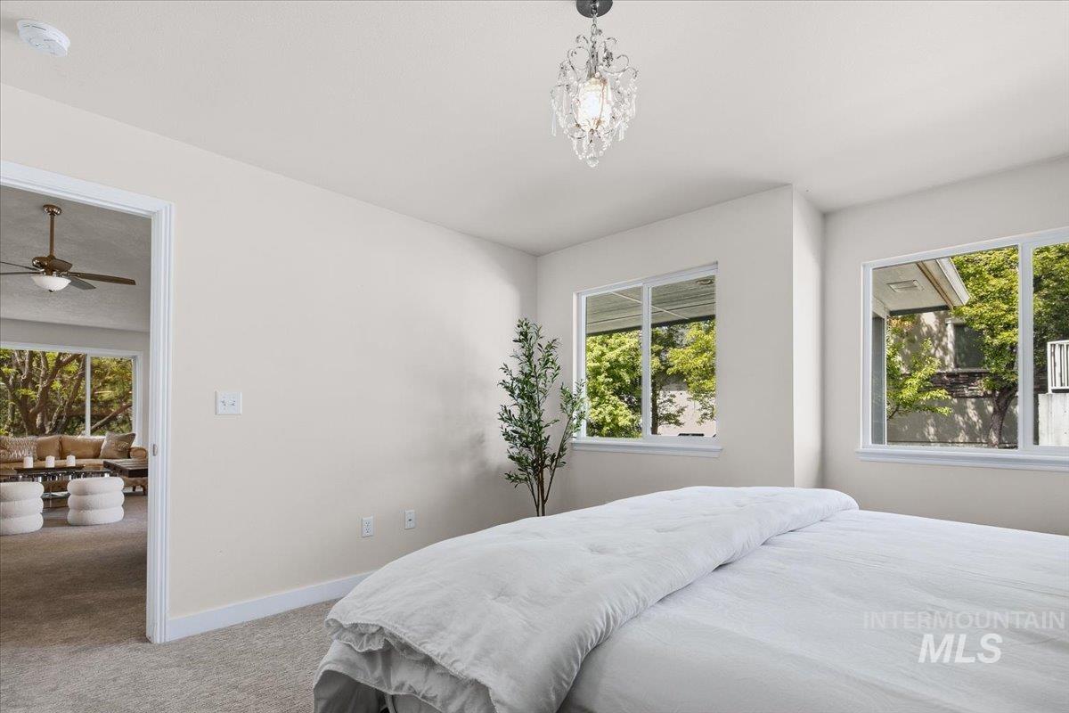 725 North Eagle Road Eagle, ID 83616 - Photo 16 of 45 Room featuring two large windows, a crystal chandelier, and neutral wall tones