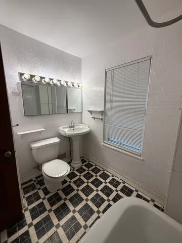 a bathroom with a sink toilet a mirror and shower