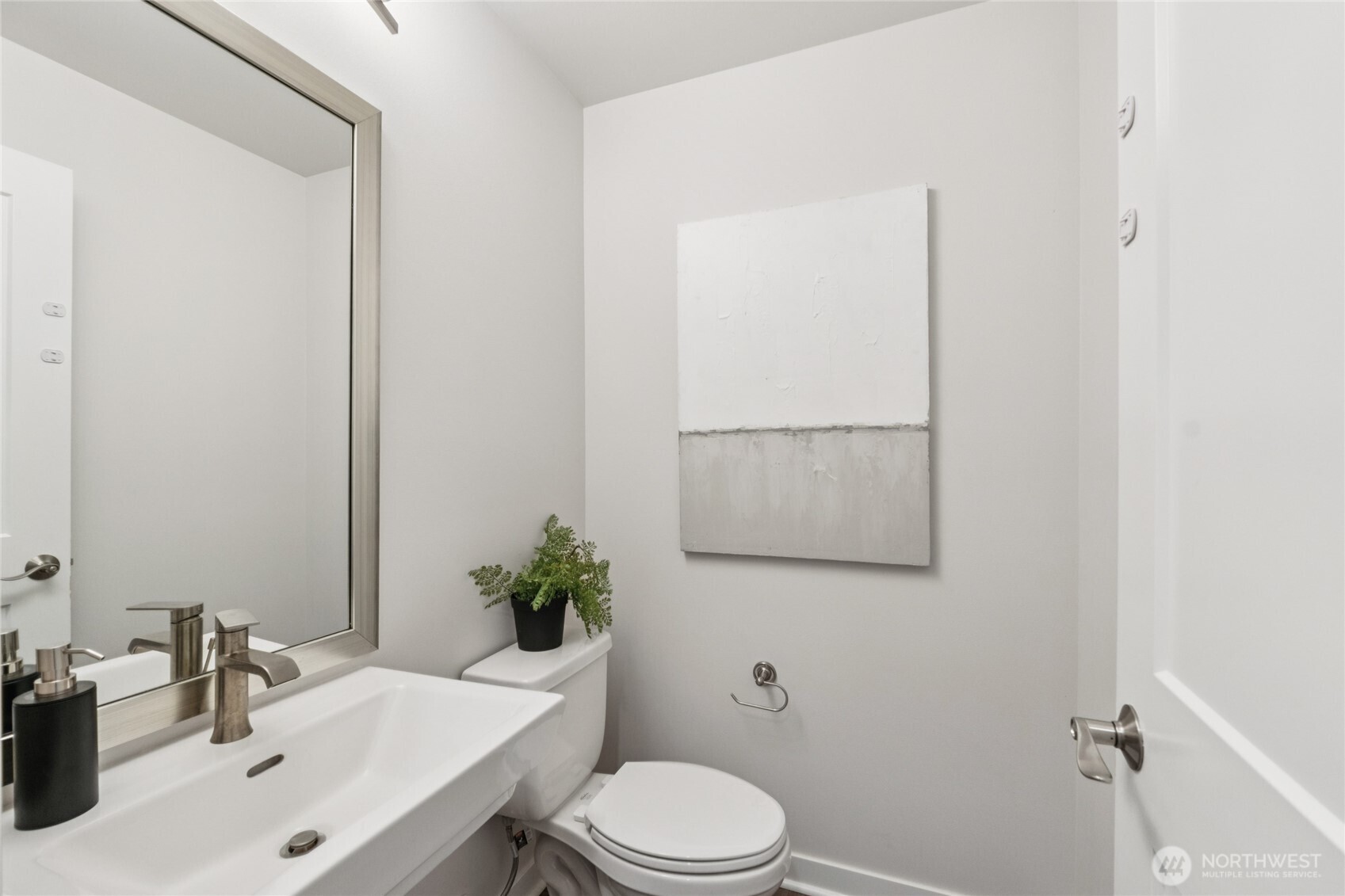 10942 Northeast 189th Place, Unit E Bothell, WA 98011 - Photo 11 of 24 a bathroom with a sink toilet and mirror
