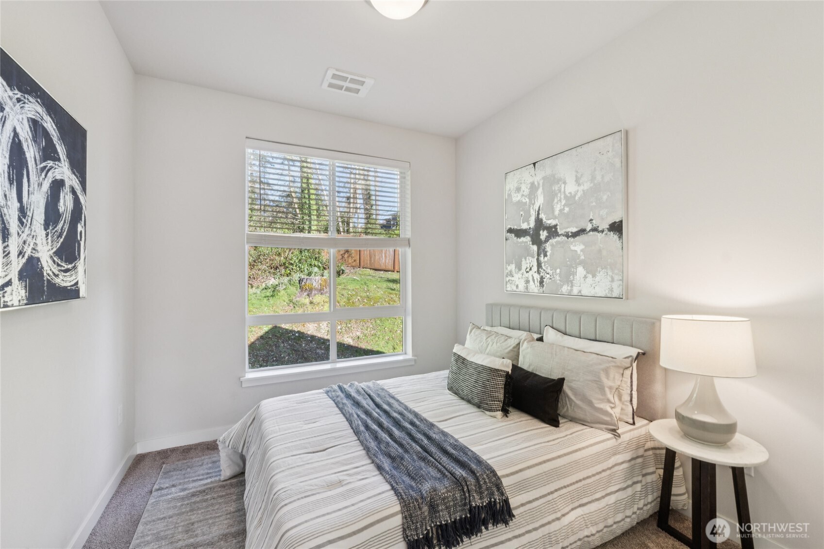 10942 Northeast 189th Place, Unit E Bothell, WA 98011 - Photo 18 of 24 a bedroom with a bed and a window