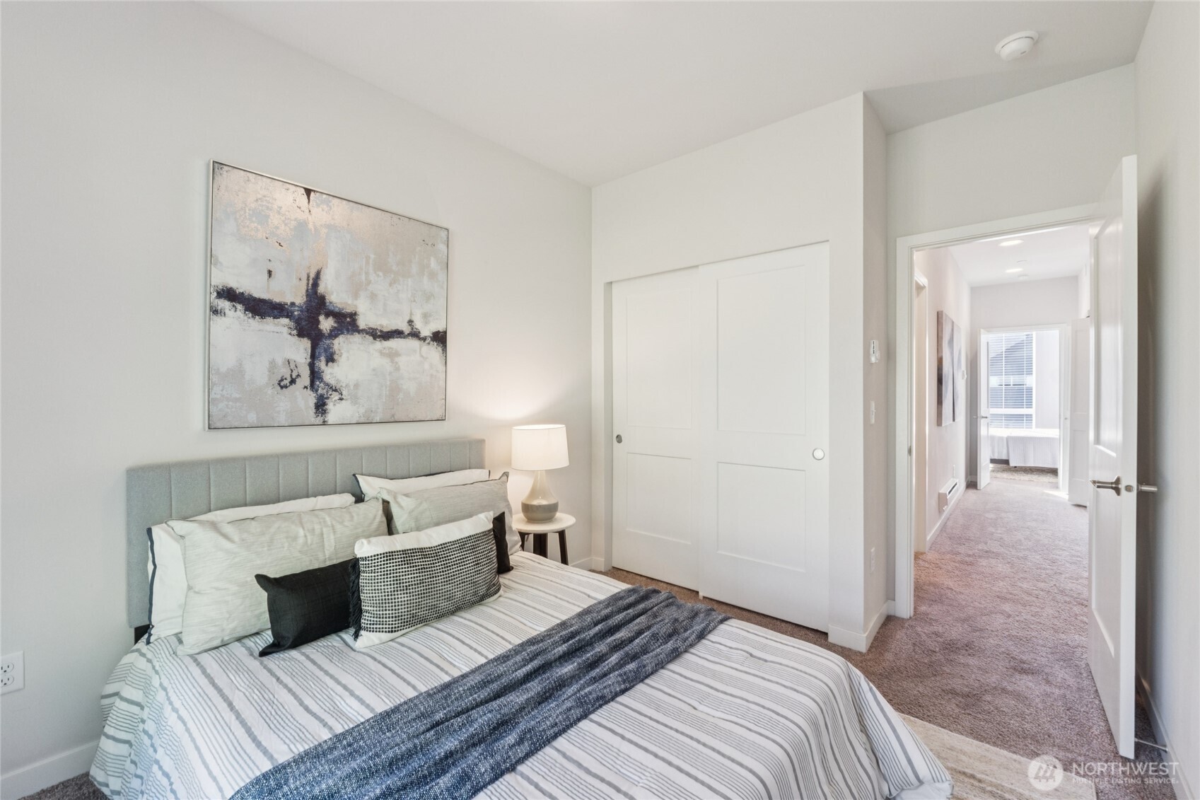 10942 Northeast 189th Place, Unit E Bothell, WA 98011 - Photo 19 of 24 a bedroom with a bed and a painting on the wall