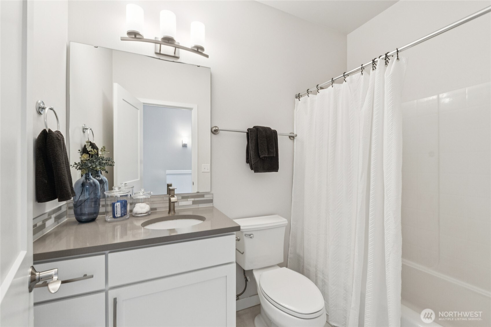 10942 Northeast 189th Place, Unit E Bothell, WA 98011 - Photo 20 of 24 a bathroom with a granite countertop sink vanity mirror and toilet