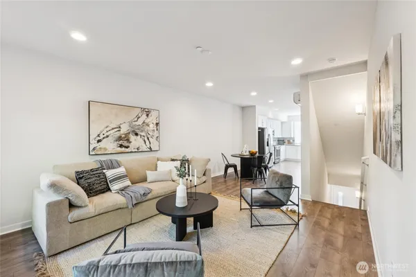 a living room with furniture and a view of kitchen