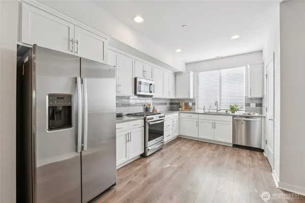 a kitchen with a refrigerator a sink and cabinets