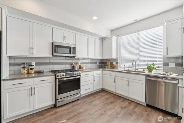 a kitchen with granite countertop white cabinets and white appliances