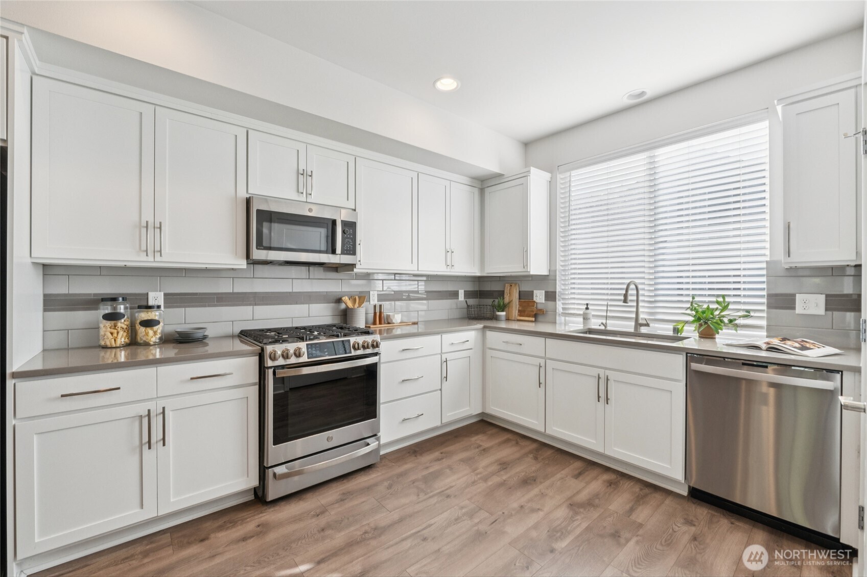 10942 Northeast 189th Place, Unit E Bothell, WA 98011 - Photo 9 of 24 a kitchen with granite countertop white cabinets and white appliances