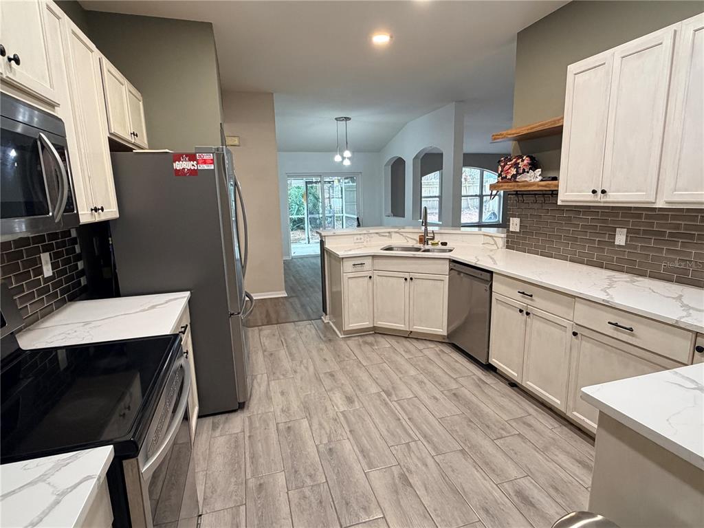 4111 Amber Ridge Lane Valrico, FL 33594 - Photo 13 of 27 a kitchen with a sink dishwasher a refrigerator and cabinets