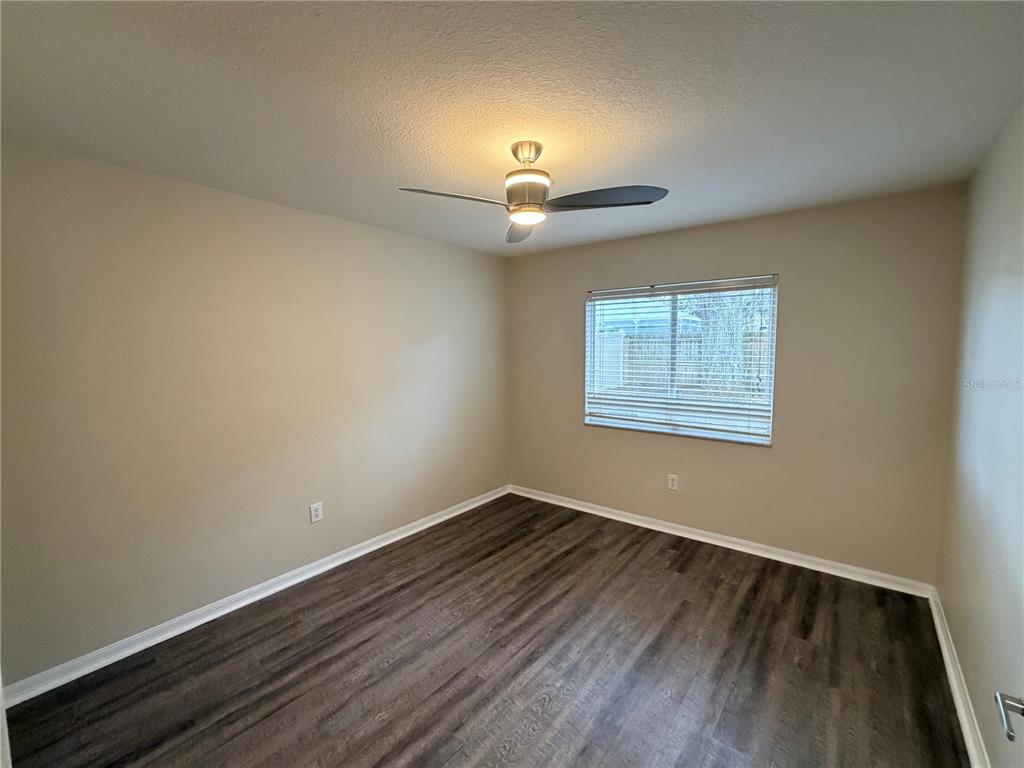 4111 Amber Ridge Lane Valrico, FL 33594 - Photo 20 of 27 an empty room with wooden floor chandelier fan and windows