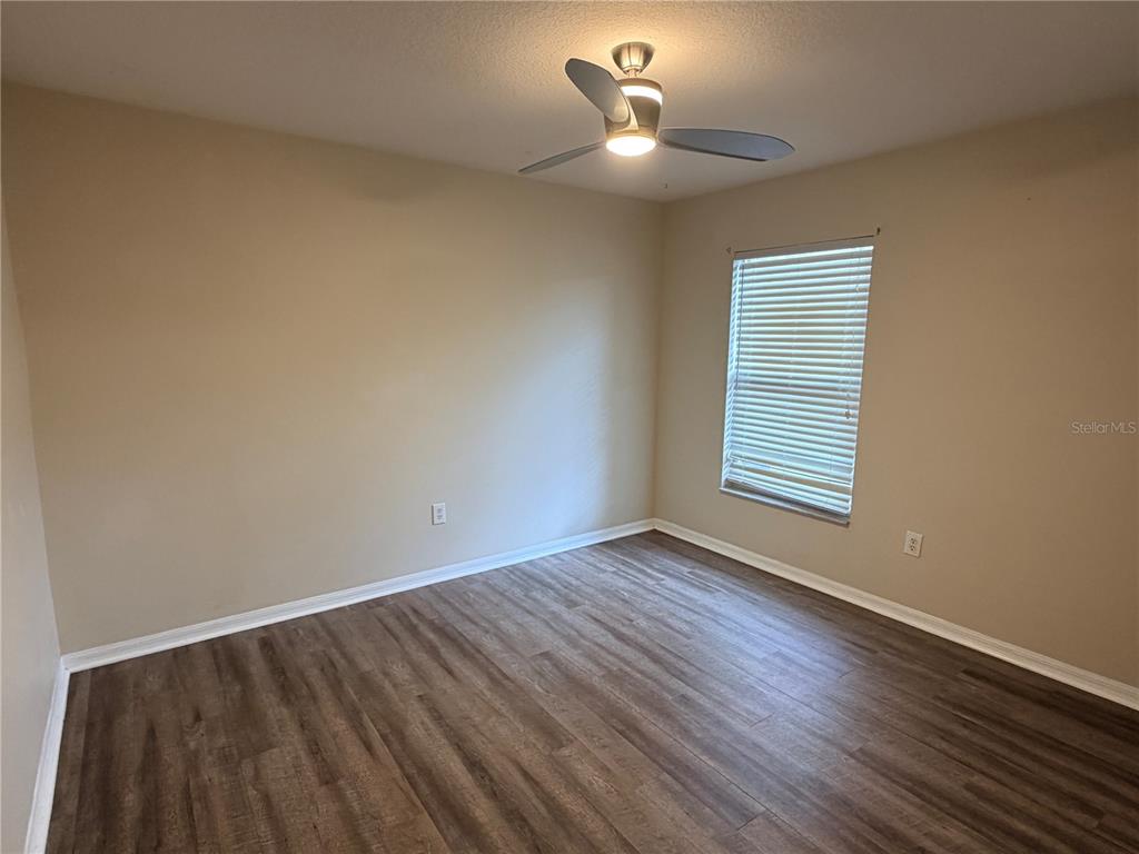 4111 Amber Ridge Lane Valrico, FL 33594 - Photo 21 of 27 a view of an empty room with wooden floor and a window