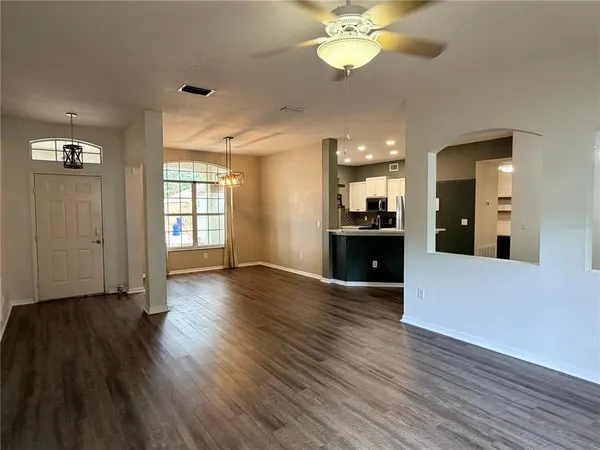 a view of a big room with wooden floor and windows