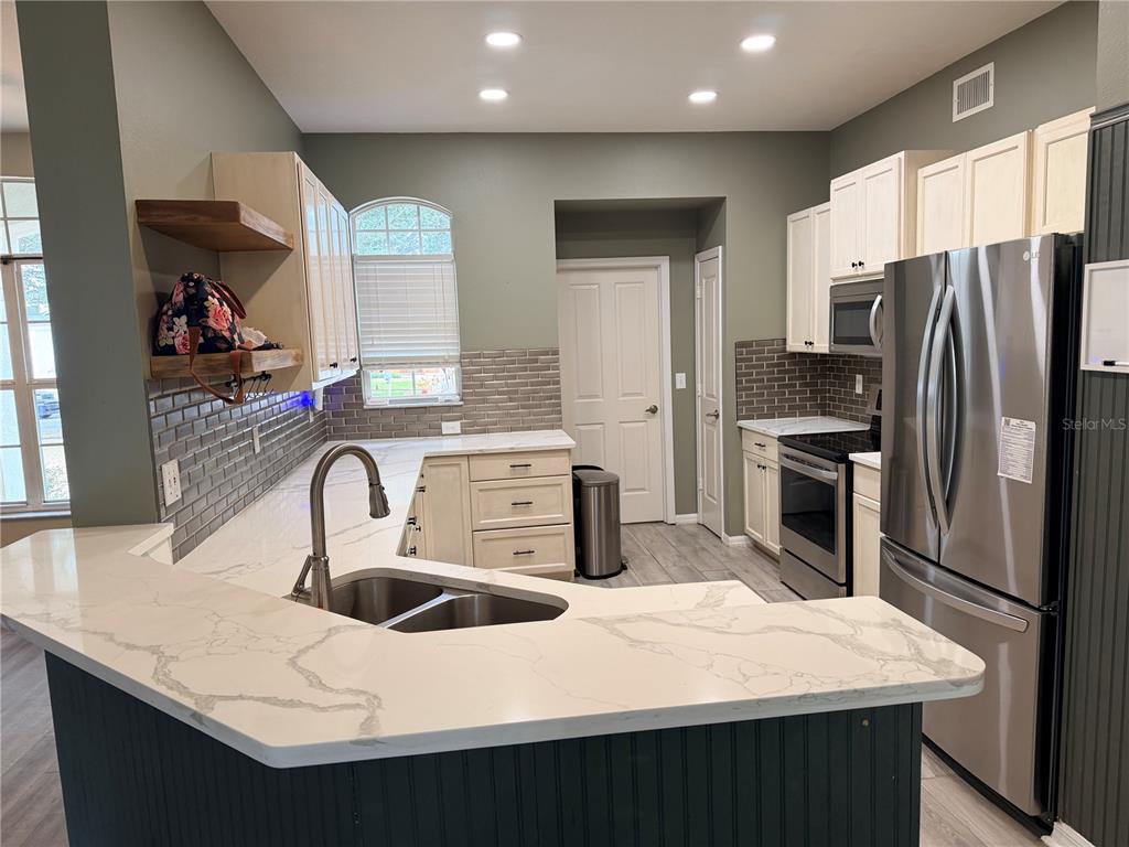 4111 Amber Ridge Lane Valrico, FL 33594 - Photo 10 of 27 a kitchen with stainless steel appliances a sink a counter top space cabinets and stainless steel appliances