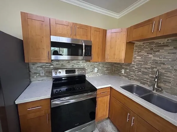 a kitchen with a sink stove and microwave