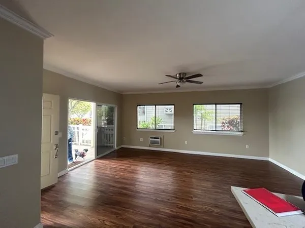 an empty room with wooden floor and windows