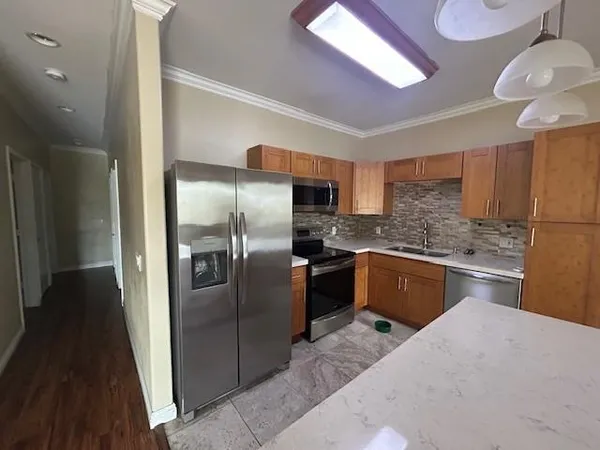 a kitchen with granite countertop a refrigerator and wooden cabinets