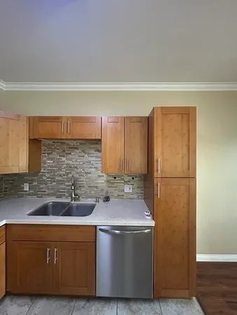 a kitchen with stainless steel appliances granite countertop a sink a refrigerator a washer and dryer