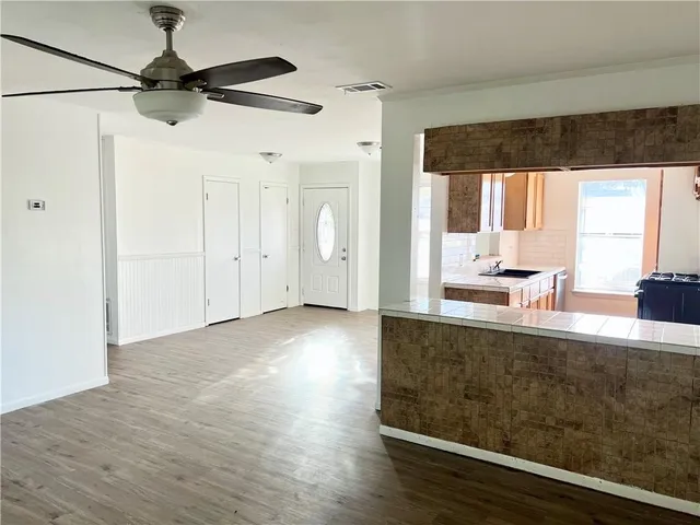a view of a living room with hardwood floor and a ceiling fan