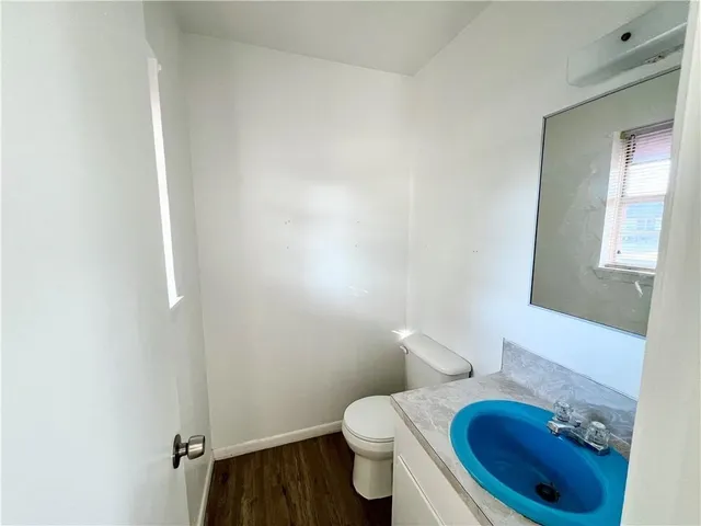a bathroom with a granite countertop toilet and a sink