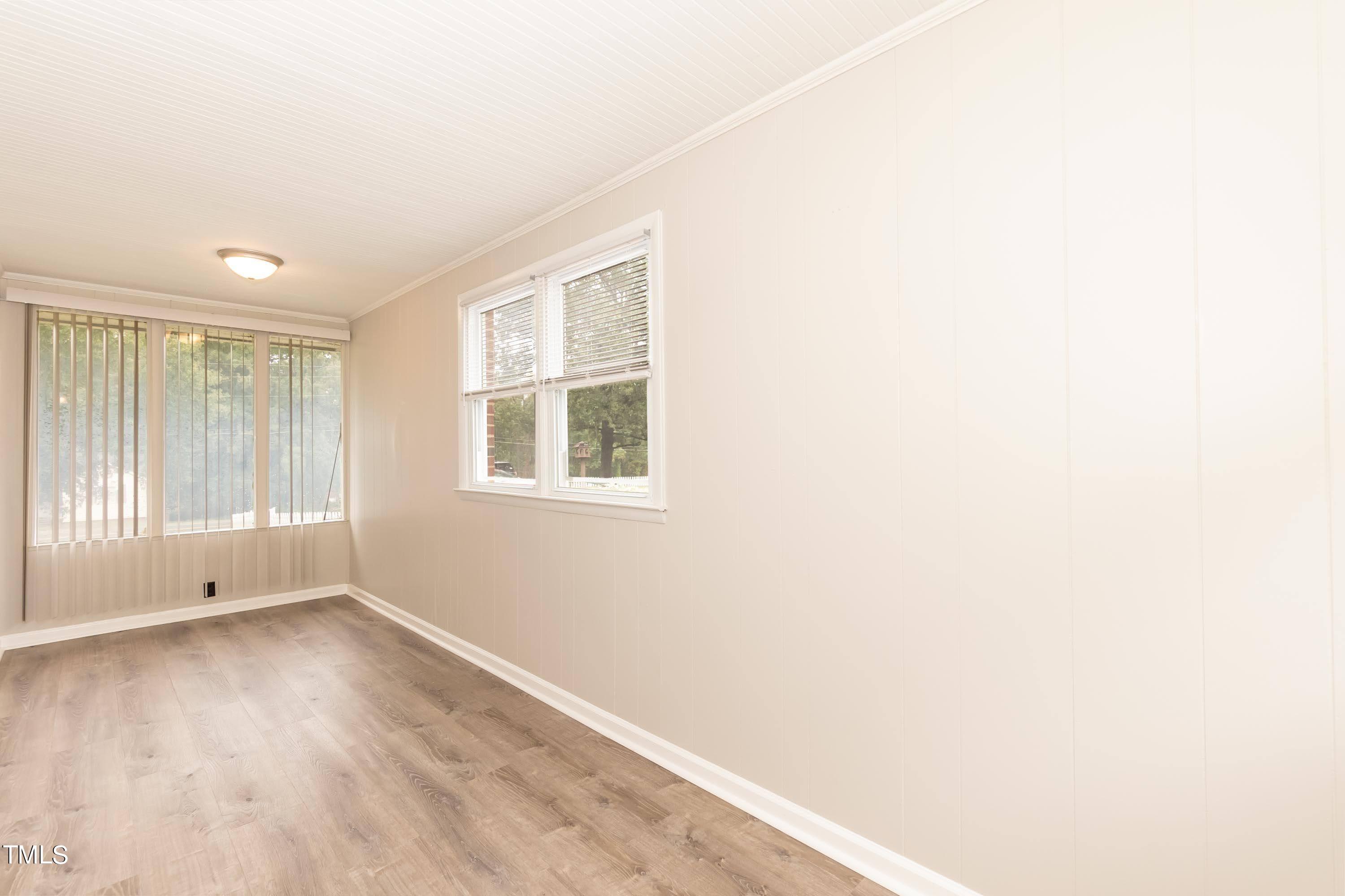 139 Johnson Street Roxboro, NC 27573 - Photo 12 of 30 an empty room with wooden floor and windows