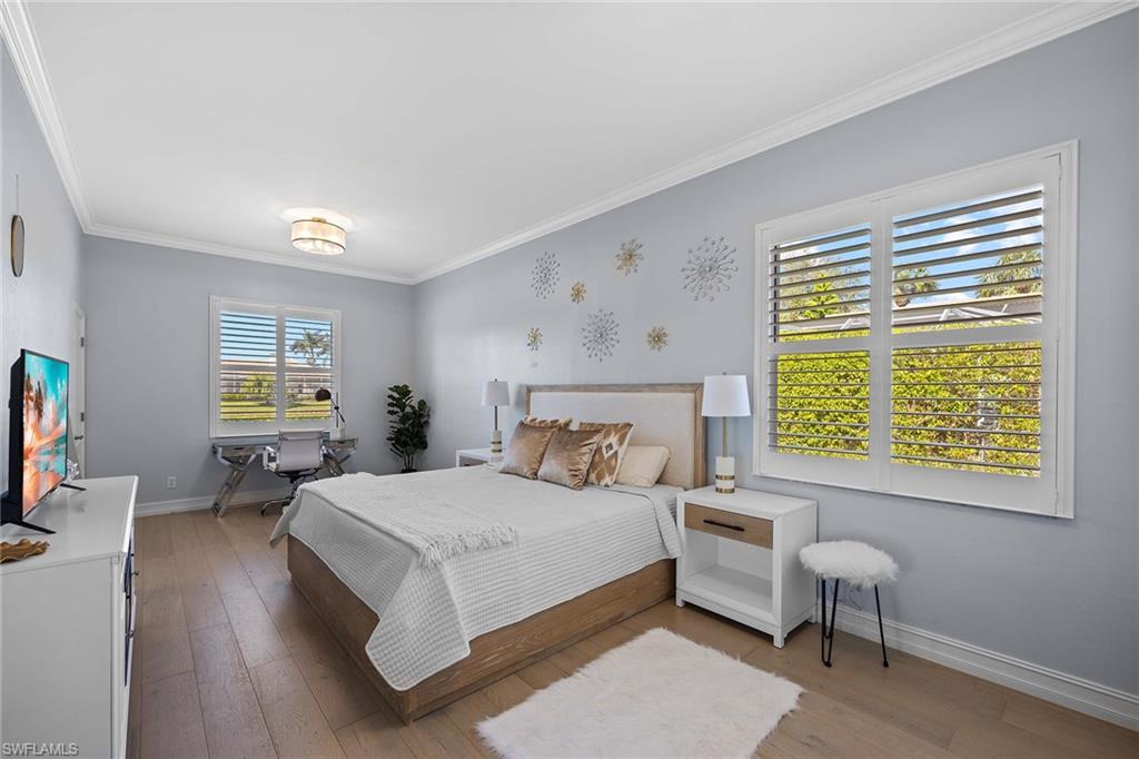 8943 Lely Island Circle Naples, FL 34113 - Photo 21 of 40 a bedroom with a bed and a chair
