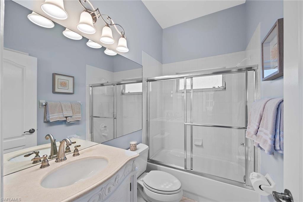 8943 Lely Island Circle Naples, FL 34113 - Photo 24 of 40 a bathroom with a toilet a sink and a mirror