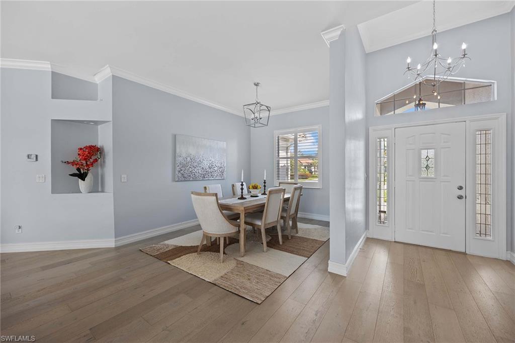 8943 Lely Island Circle Naples, FL 34113 - Photo 6 of 40 a view of a dining room with furniture and wooden floor