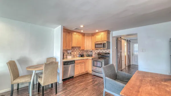 a kitchen with a table chairs refrigerator and cabinets