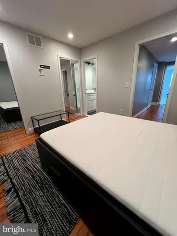 a bed sitting in a spacious bedroom next to a window