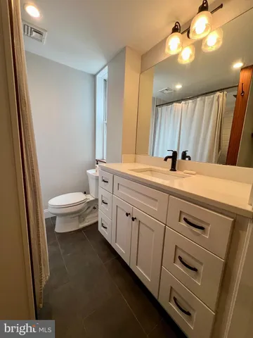 a bathroom with a sink a toilet and a mirror