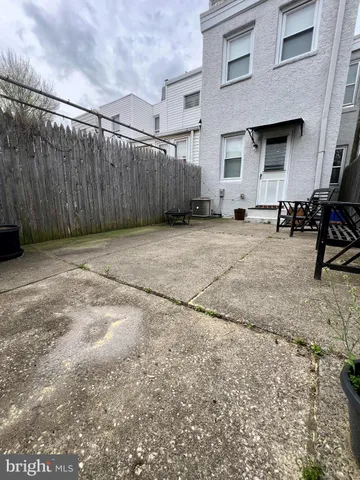 a backyard of a house with chairs and wooden fence