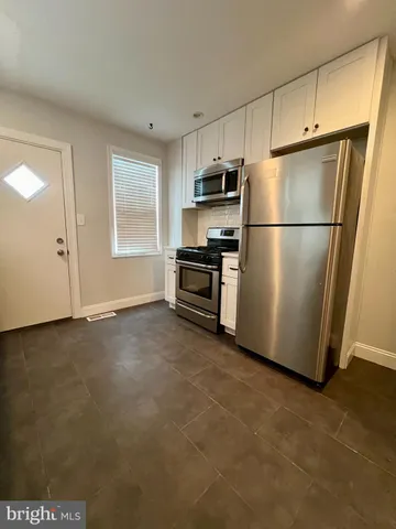 a view of kitchen with stainless steel appliances wooden floor and a window