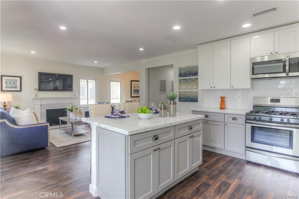 1925 North Screenland Drive Burbank, CA 91505 - Photo 1 of 31 a kitchen with stainless steel appliances granite countertop a stove top oven a sink dishwasher and a refrigerator with wooden floor