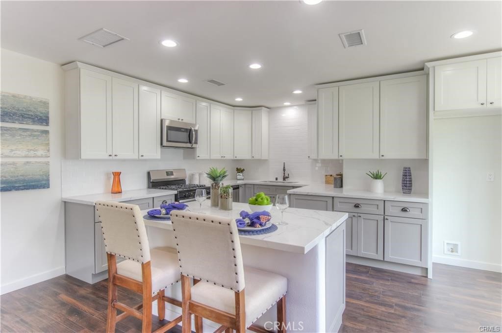 1925 North Screenland Drive Burbank, CA 91505 - Photo 11 of 31 a kitchen with kitchen island granite countertop a sink cabinets and wooden floor