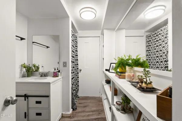 a bathroom with a toilet a sink a mirror and a window