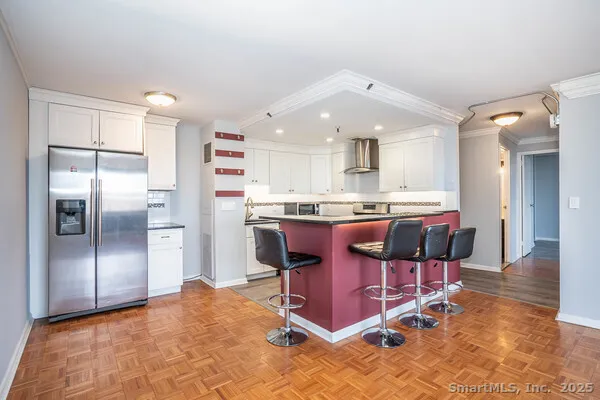 a kitchen with stainless steel appliances kitchen island granite countertop a refrigerator and a stove top oven