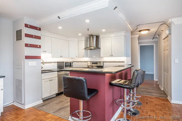a kitchen with granite countertop wooden floors and appliances