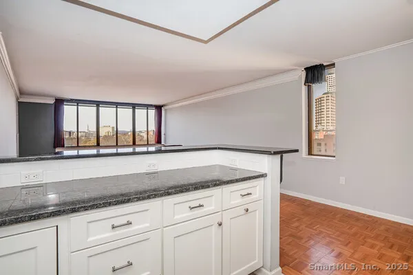 a kitchen with granite countertop a sink and white cabinets