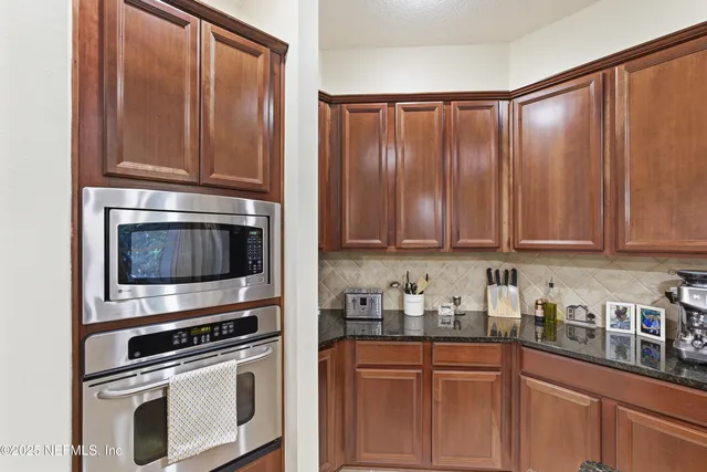 a kitchen with granite countertop wooden cabinets and stainless steel appliances