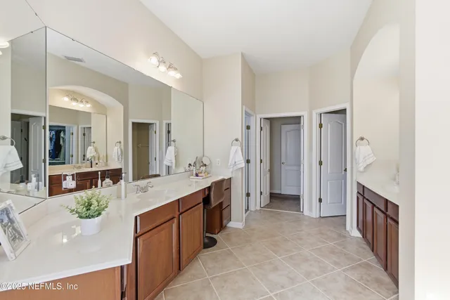 a large bathroom with a large mirror vanity and shower