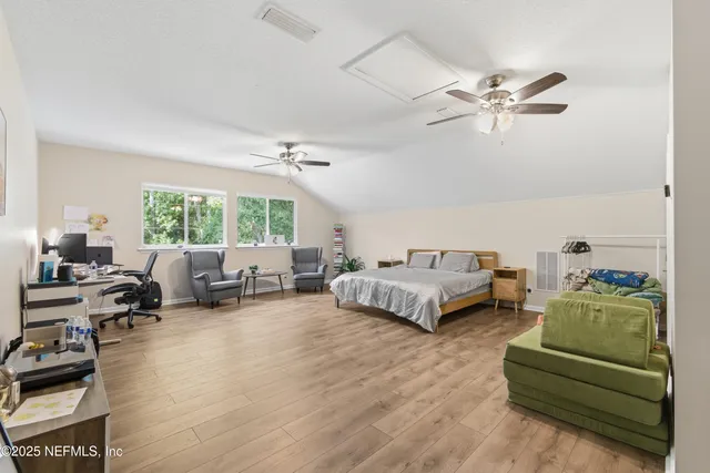 a bedroom with furniture and a large window