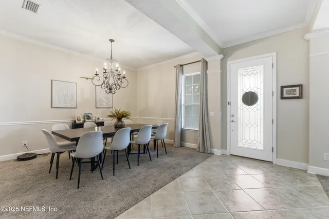 a view of a dining room with furniture and chandelier