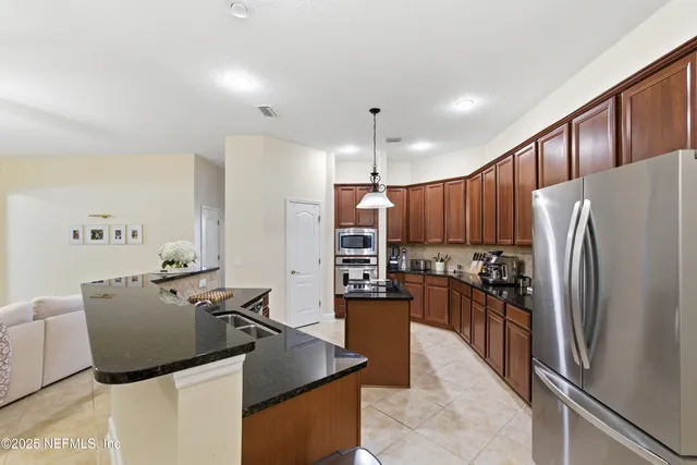 a kitchen with stainless steel appliances granite countertop a refrigerator a stove and a refrigerator