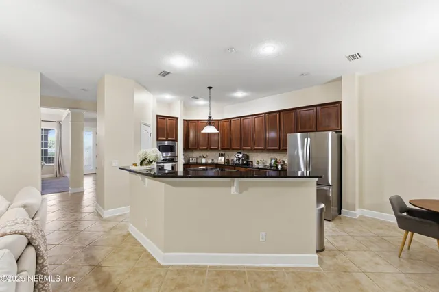 a kitchen with stainless steel appliances granite countertop a refrigerator and a stove top oven
