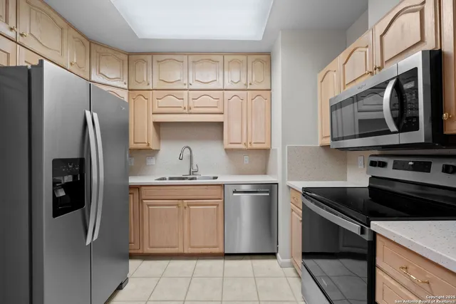 a kitchen with stainless steel appliances granite countertop a refrigerator stove top oven and sink