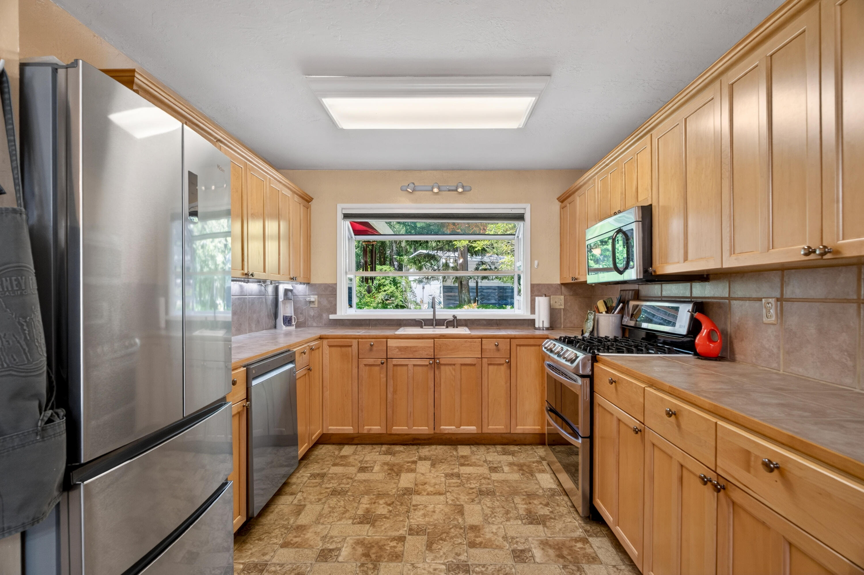 8015 Starlite Pines Road Shingletown, CA 96088 - Photo 11 of 38 a kitchen with stainless steel appliances granite countertop a refrigerator a sink dishwasher a stove and white cabinets with wooden floor