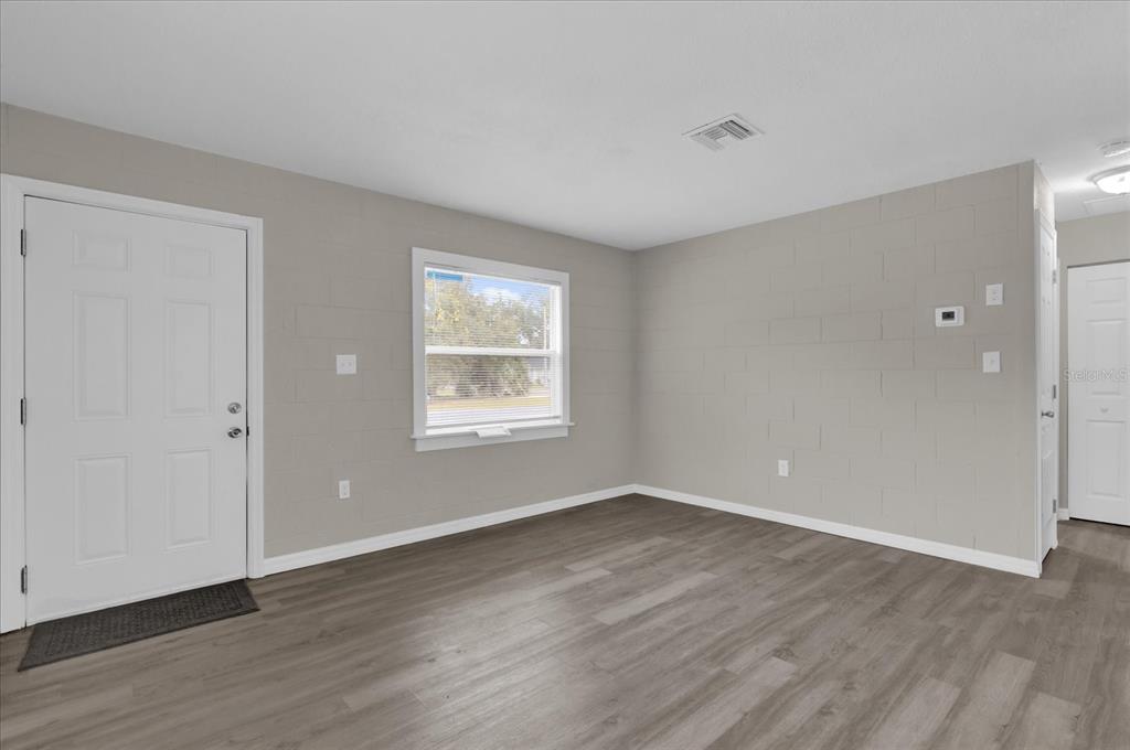 2307 Mispah Avenue, Unit A Leesburg, FL 34748 - Photo 14 of 25 a view of an empty room with wooden floor and a window