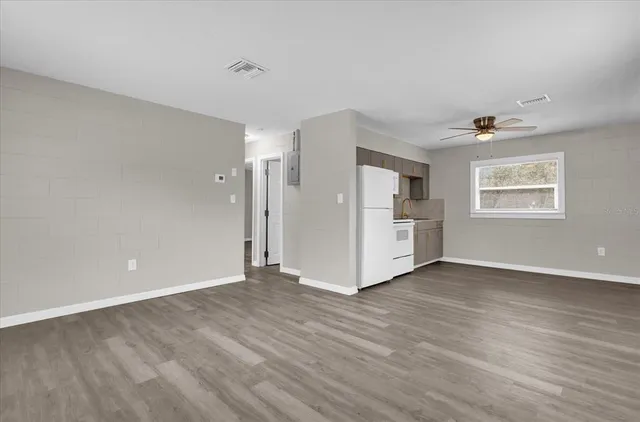 a view of an empty room with a window and wooden floor