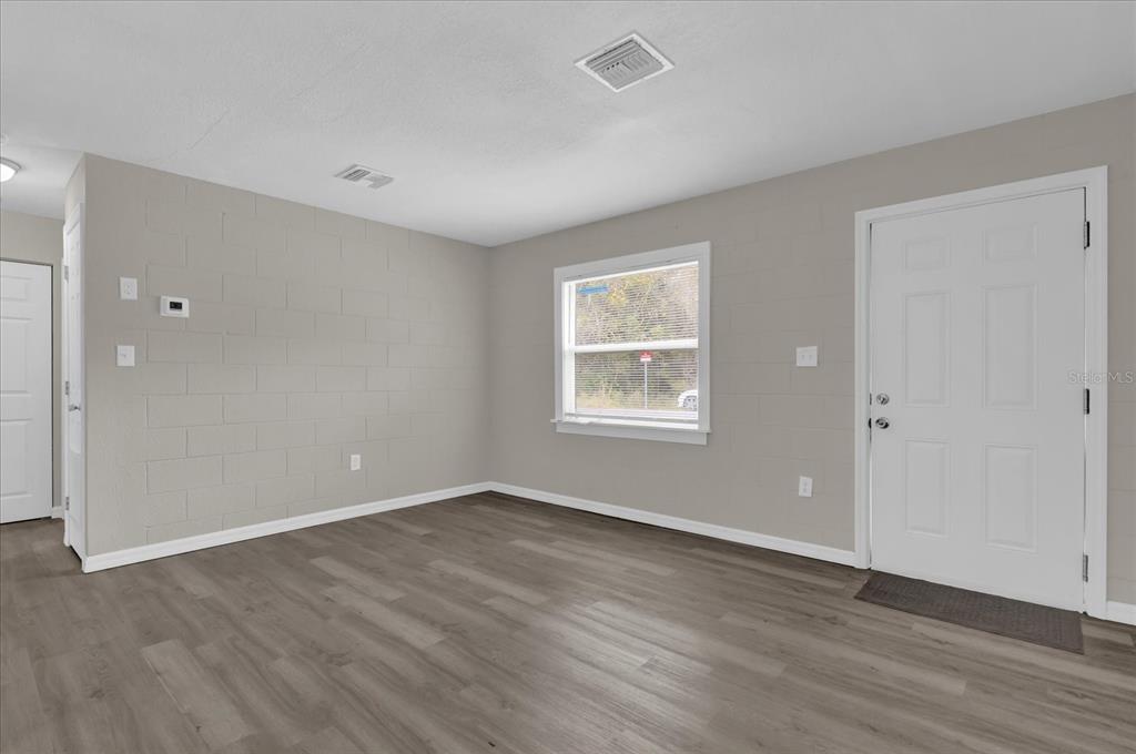2307 Mispah Avenue, Unit A Leesburg, FL 34748 - Photo 4 of 25 a view of an empty room with wooden floor and a window