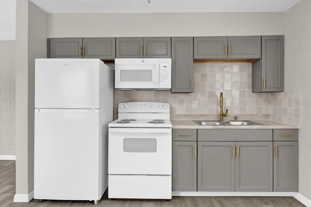 a kitchen with a refrigerator sink stove and cabinets